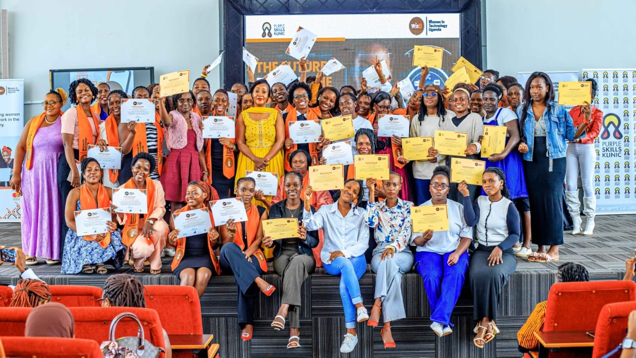 A cohort of young women graduates holding certificates on stage